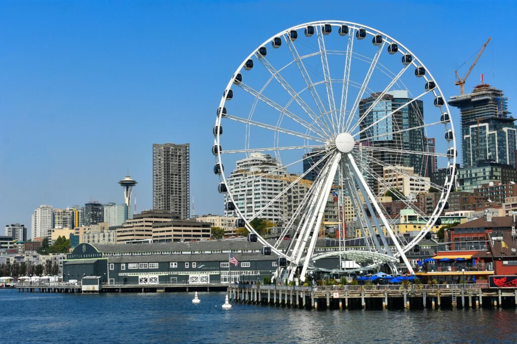 Beautiful view of the Seattle waterfront showcasing the iconic skyline, ferries, and the shimmering waters of Elliott Bay beneath a partly cloudy sky.